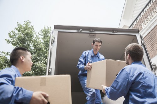 A moving team loading boxes and furniture outside a Shoreditch apartment building
